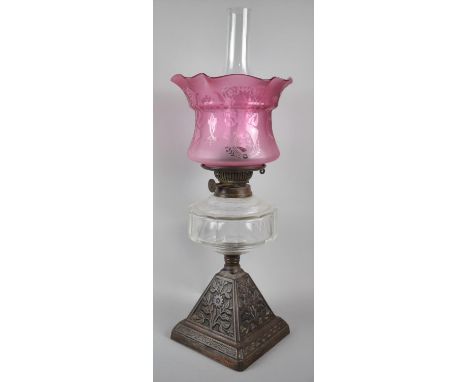 A Late 19th Century Iron Based Oil Lamp with Clear Glass Reservoir and Etched Cranberry Shade, 57cm high 
