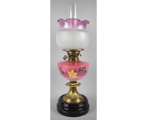 A Late 19th/Early 20th Century Brass Based Oil Lamp with Painted Cranberry Opaque Glass Reservoir and Cranberry Edged Shade, 