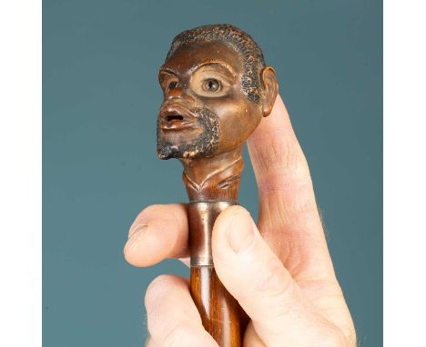 A 19th century umbrella or parasol, the novelty finial in the form of a carved gentleman's head with automata movement sticki