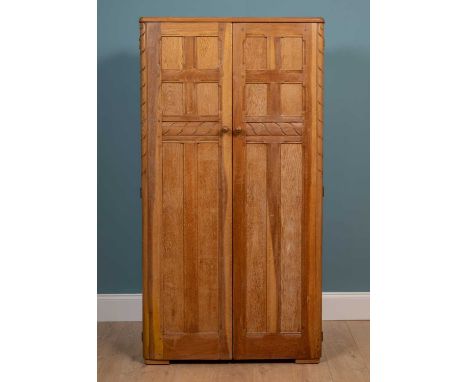 An early to mid 20th century Ercol two-door wardrobe with panelled doors, of pegged construction and with label to the revers