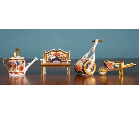 Four Royal Crown Derby ‘garden’ ornaments, decorated in Imari colours, consisting of a bench, a roller, a watering can and a 