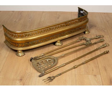 A 19th century pierced brass fender; 87cm wide; together with a set of three brass fire irons and a brass extending toasting 