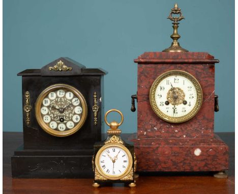 A Swiss polished metal timepiece with alarm setting, the case applied with gilt metal mounts, overhead loop handle and on fou