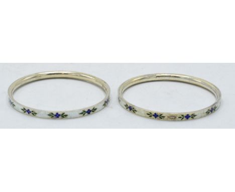 A pair of silver and enamel bangles with floral decoration, 7cm diameter.  