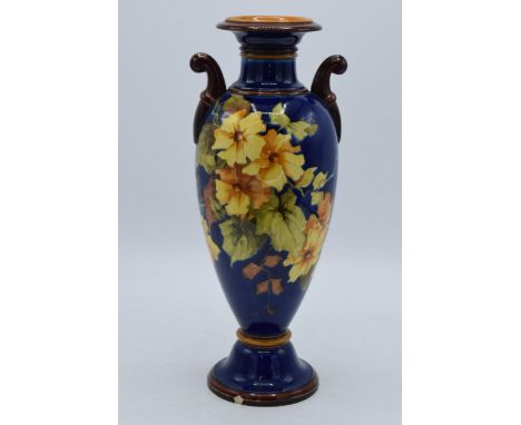Doulton Lambeth Faience vase on dark blue back ground with twin handles (slight af).  In good condition with no obvious damag