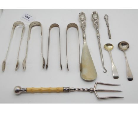 A lot comprising two pairs of silver sugar tongs, white metal tongs, a shoehorn and buttonhook set, two mustard spoons and a 