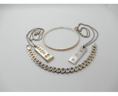 A silver and 9ct gold slave bangle, a silver heart shaped link bracelet and two ingot pendants Condition Report: Not availabl