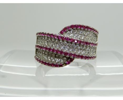 A silver dress ring of cross over design set with clear and pink gems, size N1/2 Condition Report: Available upon request