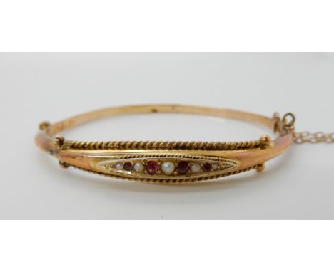 A 9ct gold pearl and red gem set bangle, weight 5.1gms Condition Report: Available upon request