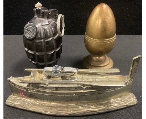 A novelty lighter, as a Maltese boat, 15cm long, 6cm high; another, as an egg and cup, 9cm high; a wax candle in the form of 