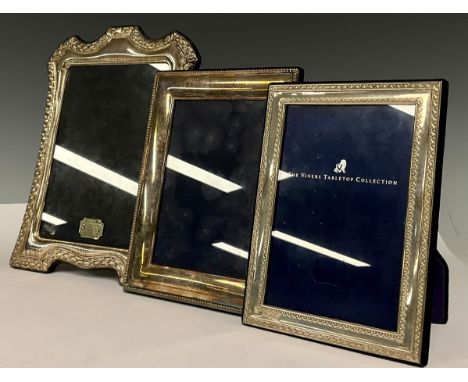 An Elizabeth II silver shaped rectangular easel photograph frame, 25cm high, Sheffield 1996; other silver photograph frames (