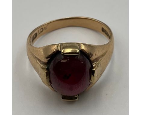 A 9ct Gold Cabochon Garnet Ring;set with an oval cabochon garnet that measures approx. 9mm x 7mm, stamped "9CT", ring size K,