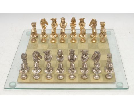 A gilt and silvered metal figural chess set, cast in the Renaissance taste, the glass board 38cm wide