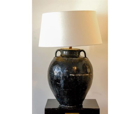 A large black-glazed lamp with a white shade.H.: 87 x diam.: 57 cm. 