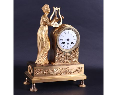 A 19th century fire-gilt mantel clock with harp-playing muse.H.: 37 cm. 