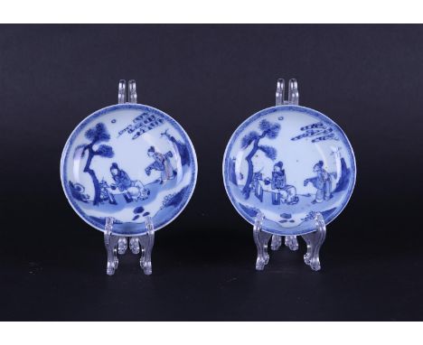 Two porcelain plates with rich decoration of a dignitary at a table and a servant with a stringed instrument. China, Kangxi/Y