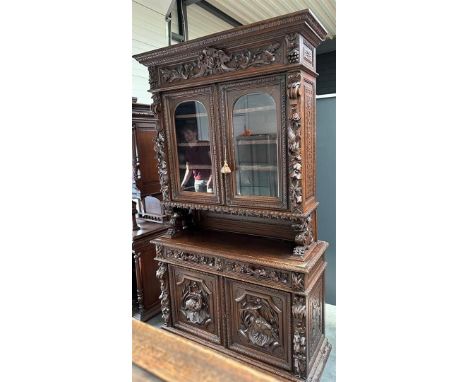 A French, antique hunting cupboard, the revolt carried by abstracted lions, with glass doors and three shelves decorated on b