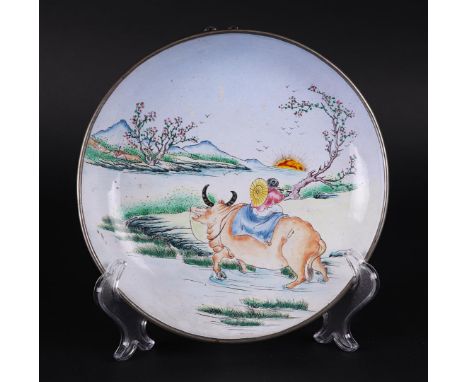 An enamel plate decorated with a water buffalo and a figure in a landscape. China, 18/19th century.Diam.: 21 cm.