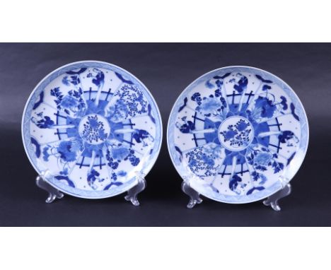 A set of two porcelain dishes decorated with flowers in flower beds, marked Kangxi. China, 19th century.Diam. 25 cm.