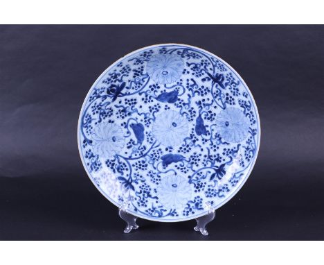 A large porcelain dish decorated with chrysanthemums and grapes, marked symbol in a double ring. China, Kanxi.Diam. 35,5 