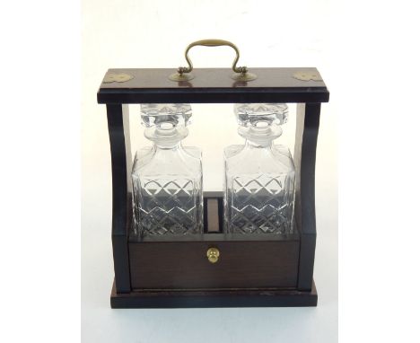 A reproduction mahogany two bottle decanter stand the brass bound frame housing two spirit decanters.