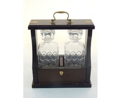 A reproduction mahogany two bottle decanter stand the brass bound frame housing two spirit decanters.