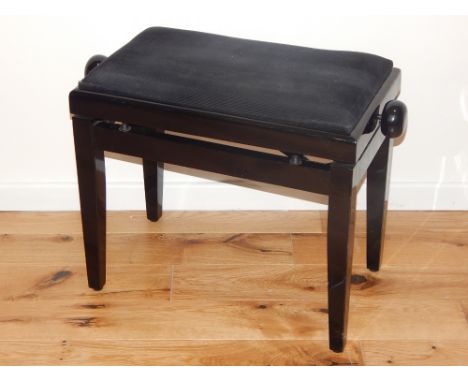 An ebonised piano stool by Stagg, with a black upholstered adjustable seat on square tapering legs.