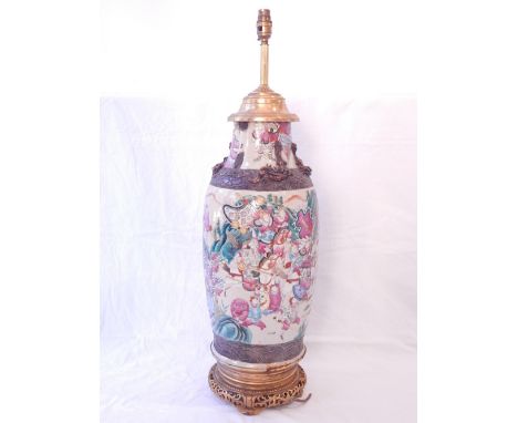 An early 20th century Chinese earthenware vase converted as a lamp, decorated with a continuous band of warriors and figures 