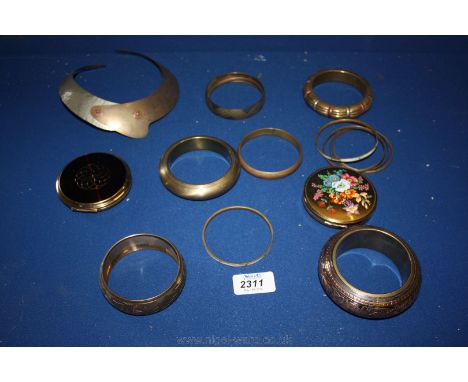 A basket of brass and copper bangles, a Stratton Compact and one other.