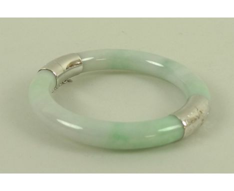 A modern jade bangle, mounted with 14ct white gold engraved hinge and clasp, with safety chain, 6cm internal and 8.5cm extern