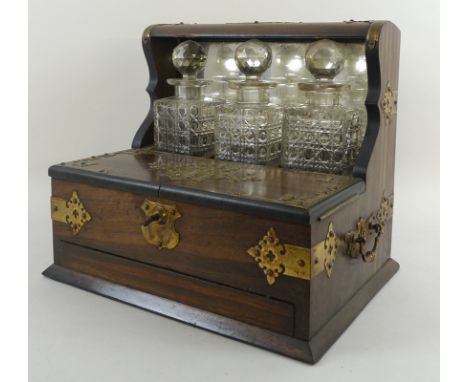A Victorian rosewood tantalus and games chest, brass bound with brass carrying handles, with three glass decanters and stoppe