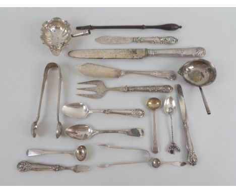 A collection of silver and silver handled flatware, including mustard spoons, tea spoons, sugar tongs, a fruit knife and fork