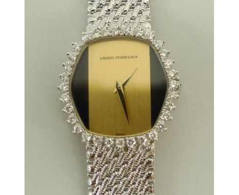 A Girard Perregaux lady's cocktail watch, circa 1970, the bezel set with thirty-two diamonds, the brushed gold and black face