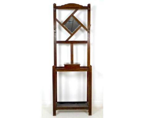 An early 20th century oak hall stand, in the Aesthetic style, with carved line decoration, with square bevelled plate mirror,