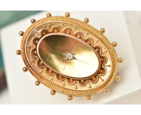 A 15CT GOLD BROOCH, an oval form Etruscan style brooch, centrally set with a single old cut diamond, approximate length 39mm,