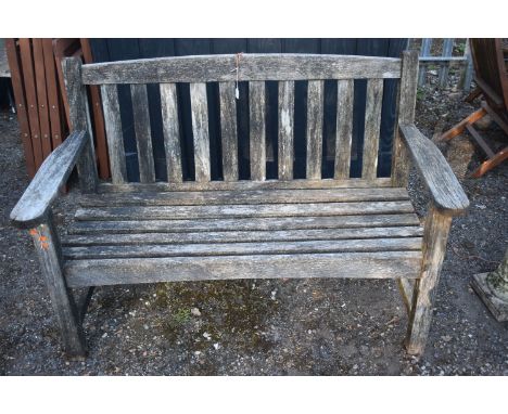A WEATHERED SLATTED TEAK GARDEN BENCH, length 130cm, condition report: rickety and not structurally sound