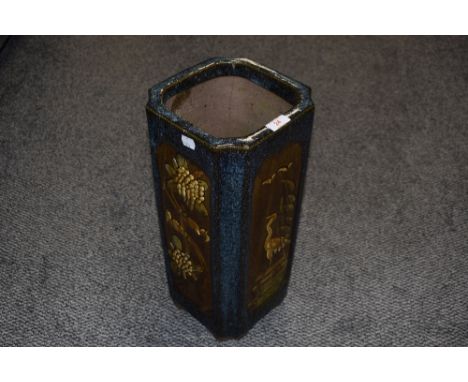 A glazed pottery stickstand or planter, of square section decorated with panels of flora and fauna and speckled blue ground, 