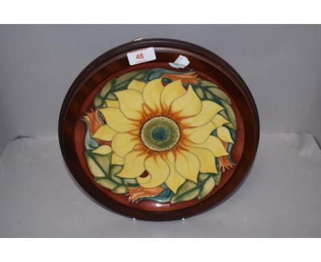 A Moorcroft Pottery 'Inca' pattern charger, designed by Rachel Bishop and tube lined with a sunflower against a washed terrac