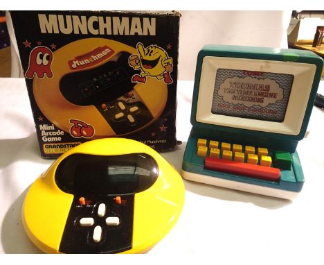 Grandstand Munchman mini arcade game in good condition. Battery compartment clean, boxed with inner packing and a Tomy Thomas