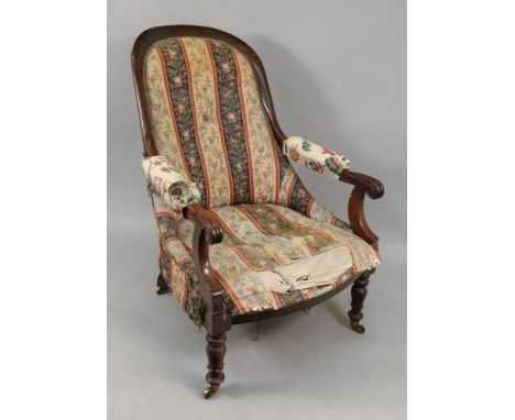 An early Victorian rosewood frame armchair, with button down upholstered arched back, arm rests and seat, on lotus carved and