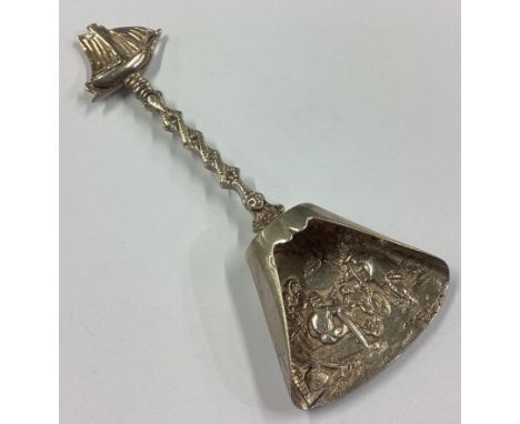 A Dutch silver caddy spoon with embossed decoration and ship terminal. Approx.19 grams. Est. £30 - £40.