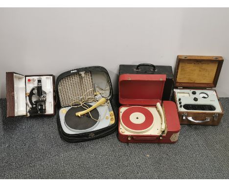 A group of vintage portable record players and a microscope.