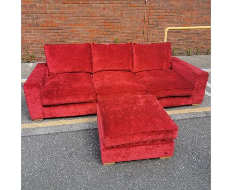 A very large red upholstered sofa with matching footstool, L. 267 H. 85 D. 110cm.