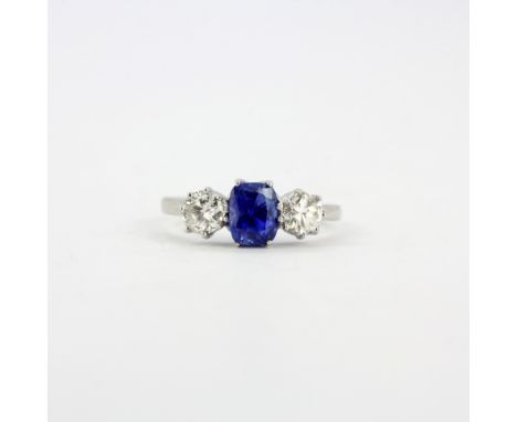 A white metal (tested high carat gold) ring set with a cushion cut sapphire and brilliant cut diamonds, approx. 0.75ct total 