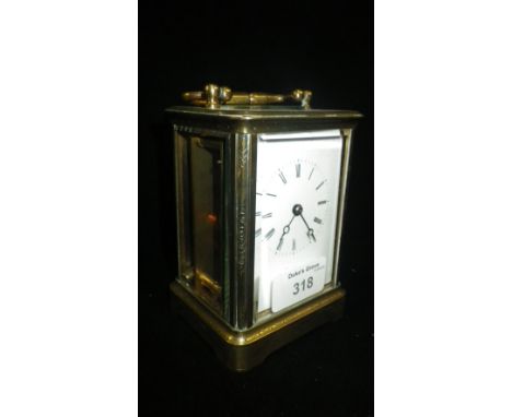 A brass-cased carriage clock with all over engraved case