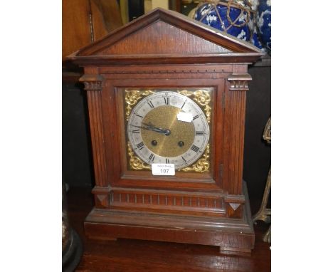 A late Victorian oak-cased mantel clock with brass dial and silvered chapter ring