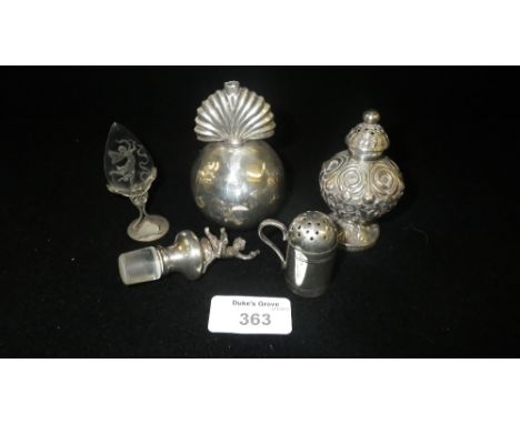 A silver flask stopper mounted with a figure clutching a glass and bottle, a miniature white metal flour dredger and other sm