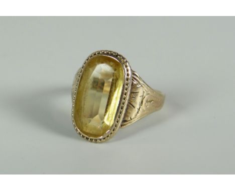 A VICTORIAN GOLD &amp; CITRINE RING the stone in a relief decorated border and with engraved shoulders, not hallmarked (or po