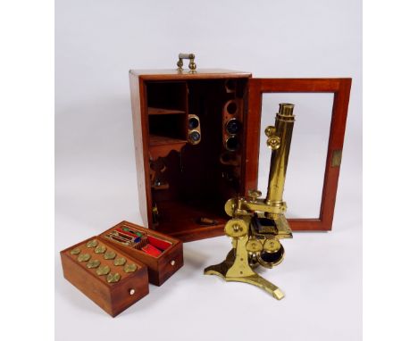 AN ANTIQUE BRASS BINOCULAR MICROSCOPE BY J H STEWARD with two rise & fall adjusters, two adjusters for the slide stage over a