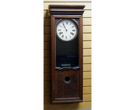 A BUNDY TIME RECORDER CLOCKING-ON MACHINE in an oak case with Bundy insignia to the facade, the clocking-on mechanism removed